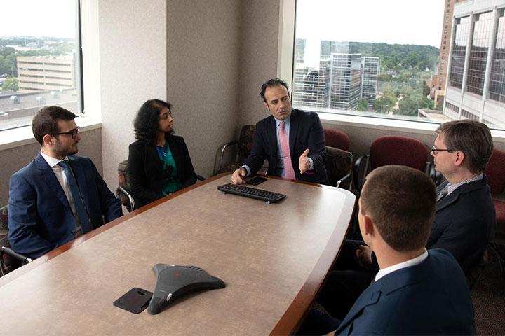 Dr. Savica, Program Director of the Movement Disorders Fellowship, speaks with fellows in a conference room at Mayo Clinic in Rochester, Minnesota.