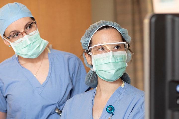 Two pediatric anesthesiologists look at a computer screen in an operating room at Mayo Clinic in Rochester, Minnesota.