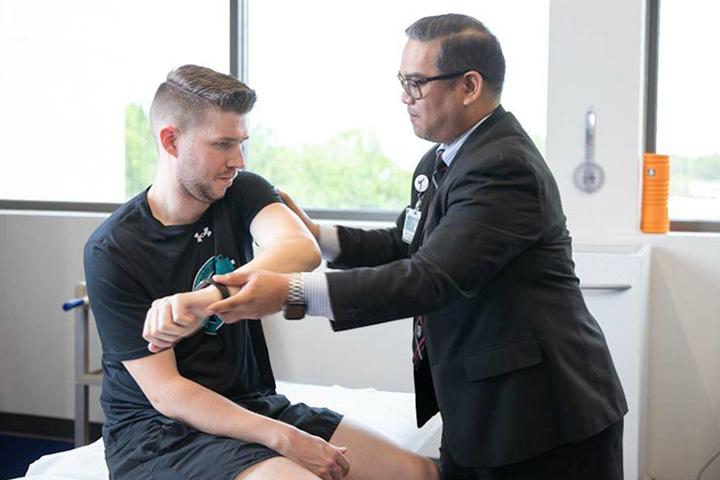 George Pujalte, M.D. working with a patient.