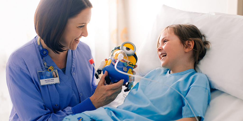 A Child Life Specialist at Mayo Clinic laughs with a pediatric patient
