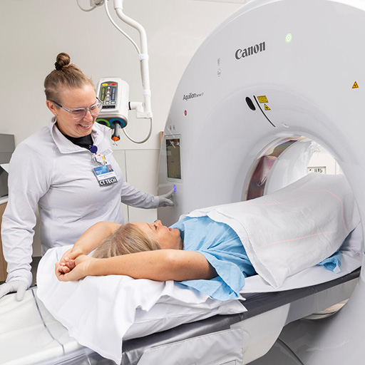 Mayo Clinic staff member assists a patient into an imaging machine
